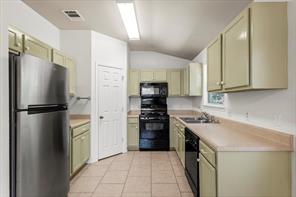 2721 Breezy Point Cove Round Rock, TX 78665 - Photo 11 of 35 a kitchen with a refrigerator a stove top oven and cabinets