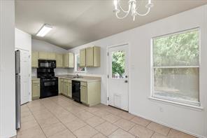 2721 Breezy Point Cove Round Rock, TX 78665 - Photo 10 of 35 a kitchen with a refrigerator a stove top oven and a large window
