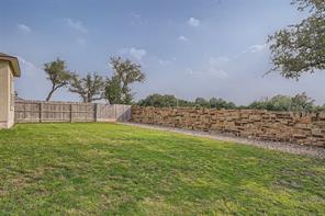 700 Mallow Road Leander, TX 78641 - Photo 27 of 28 A spacious green lawn is enclosed by a combination of wood and stacked stone fencing.