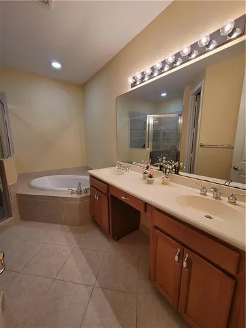 a bathroom with a tub a sink and mirror