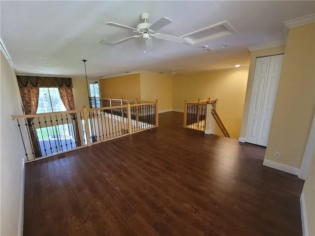 a view of a hallway with wooden floor and windows