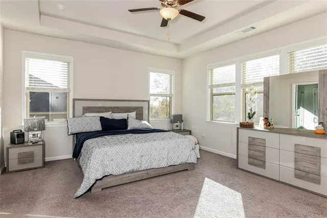 a bedroom with a large bed and a chandelier fan