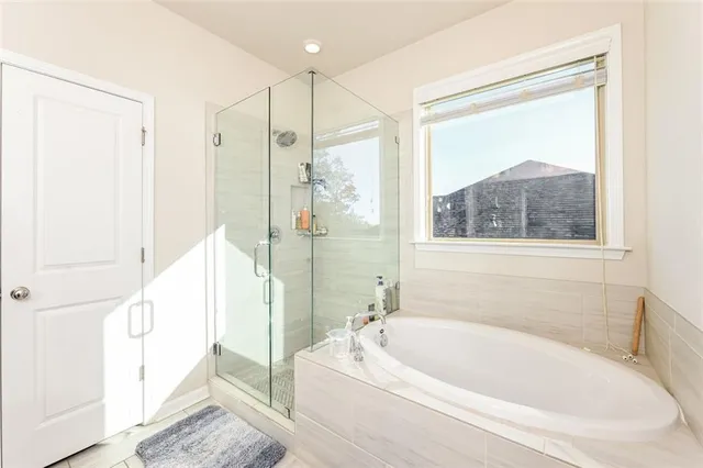 a bathroom with a tub a sink and a large mirror