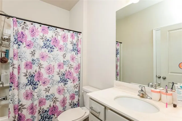 a bathroom with a sink with toilet and shower curtain