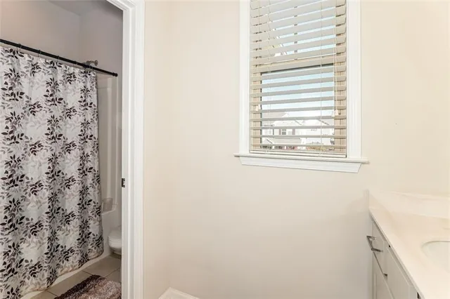 a bathroom with a shower curtain and a window