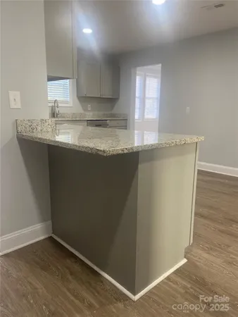 a view of a kitchen with wooden floor and a sink