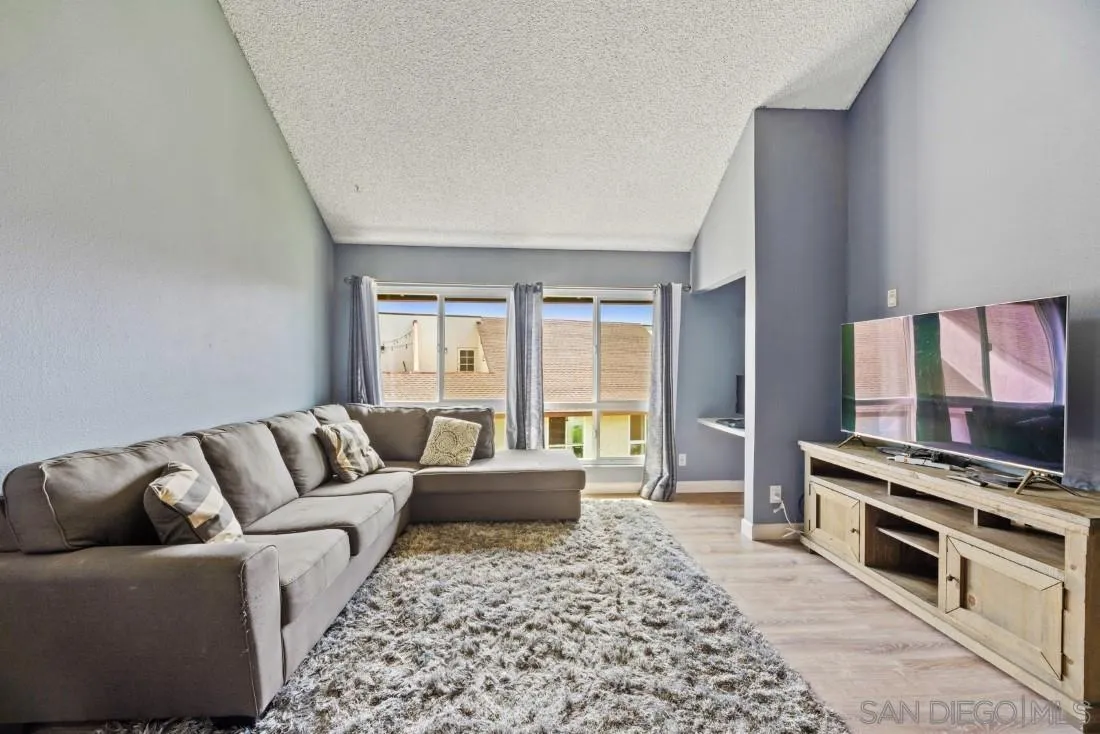 6131 Rancho Mission Road, Unit 323 San Diego, CA 92108 - Photo 3 of 11 a living room with furniture and a flat screen tv