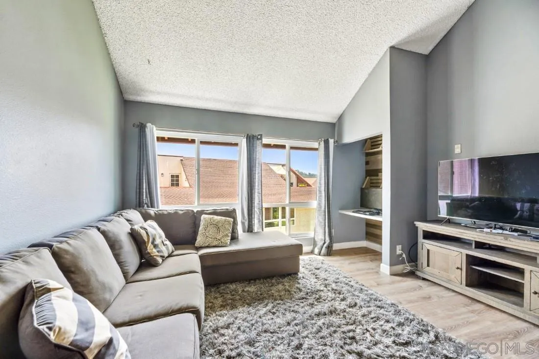 6131 Rancho Mission Road, Unit 323 San Diego, CA 92108 - Photo 4 of 11 a living room with furniture and a large window