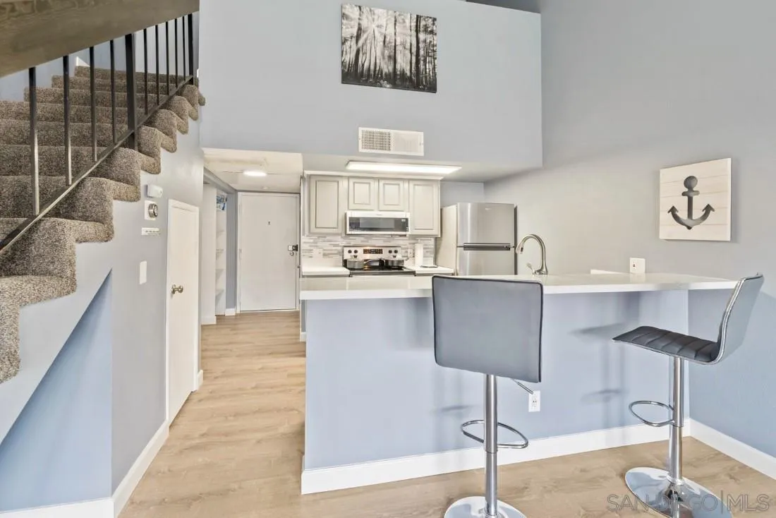 6131 Rancho Mission Road, Unit 323 San Diego, CA 92108 - Photo 5 of 11 a kitchen with cabinets and chairs