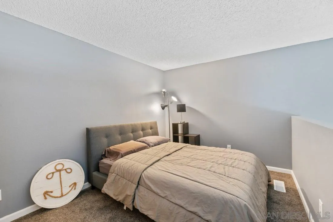 6131 Rancho Mission Road, Unit 323 San Diego, CA 92108 - Photo 7 of 11 a bedroom with a bed and a closet