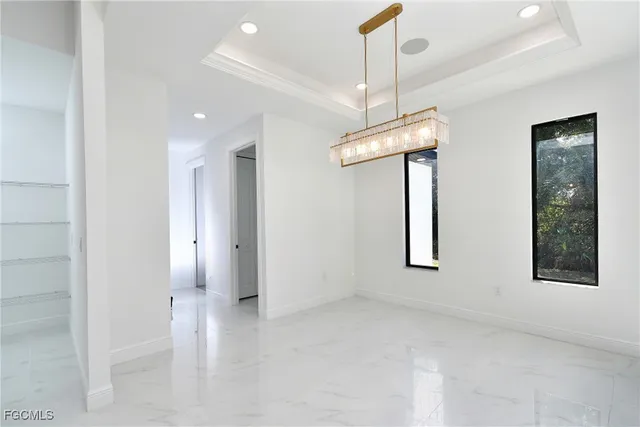 a dining room with furniture a chandelier and large windows
