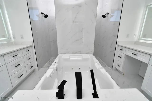a white bathroom with a sink a mirror and a shower