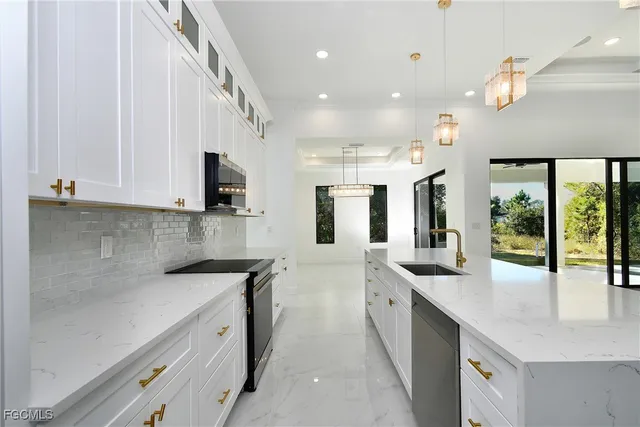 a large white kitchen with lots of counter space and a sink