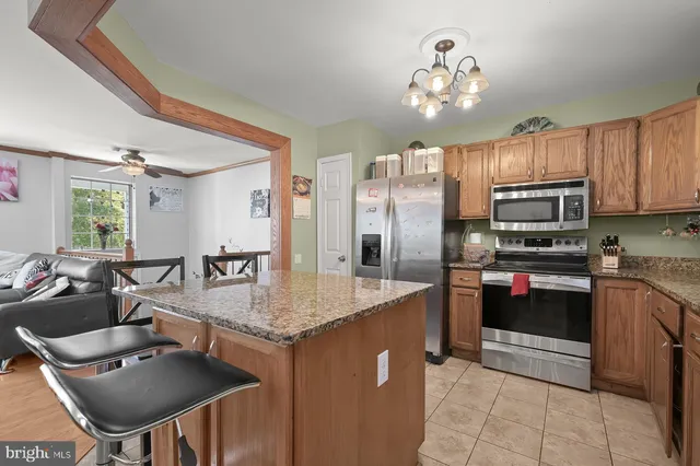 a kitchen with kitchen island granite countertop a sink counter and chairs