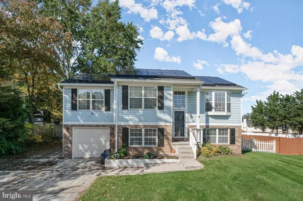a front view of a house with a yard and potted plants
