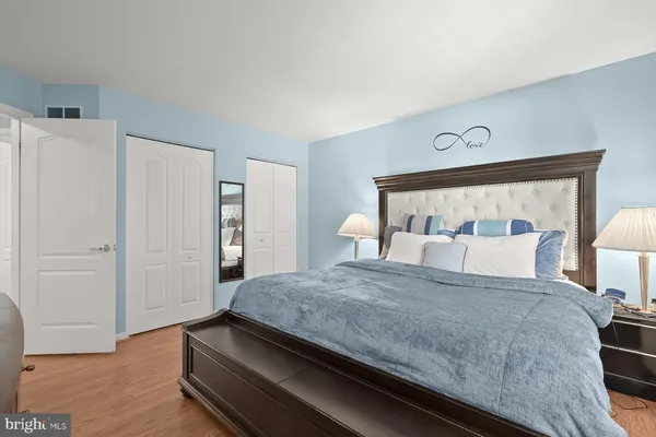 a bedroom with a large bed and wooden floor