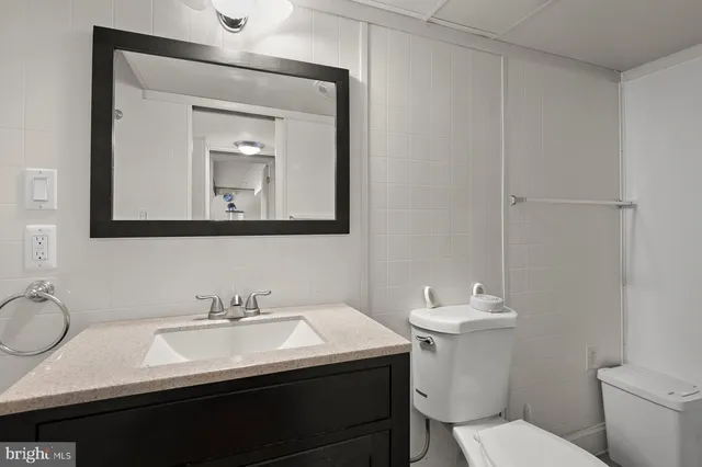 a bathroom with a toilet sink and mirror