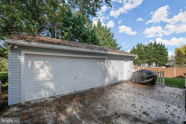 a backyard of a house with barbeque oven and wooden fence