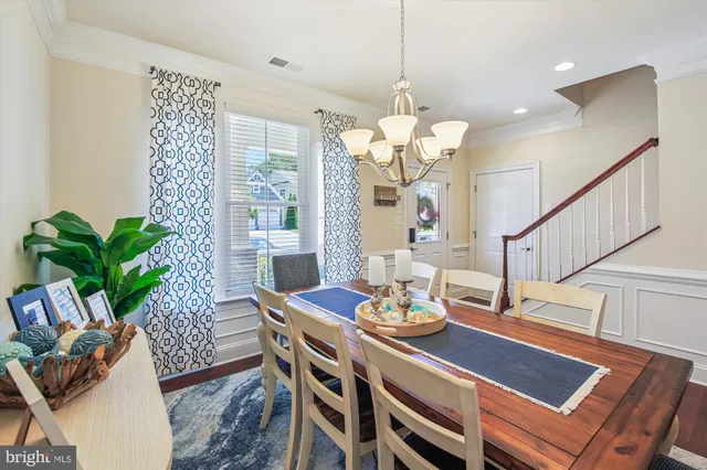 a view of a dining room with furniture a chandelier and wooden floor