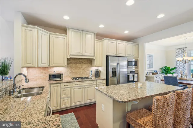 a kitchen with granite countertop white cabinets and refrigerator
