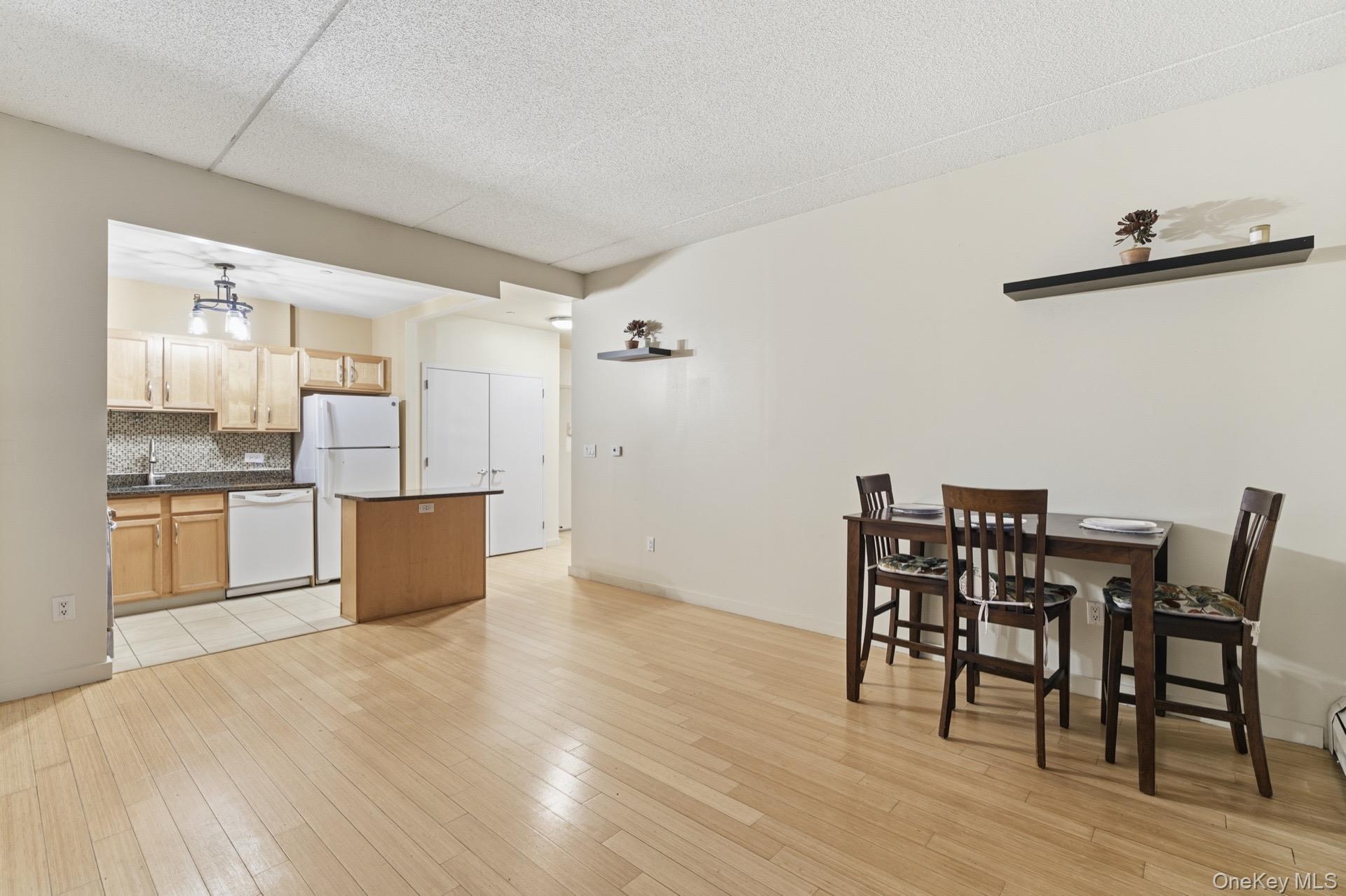 3044 3rd Avenue, Unit 9C Bronx, NY 10451 - Photo 14 of 15 Kitchen with a kitchen island, decorative backsplash, dishwasher, light wood-type flooring, and light brown cabinetry