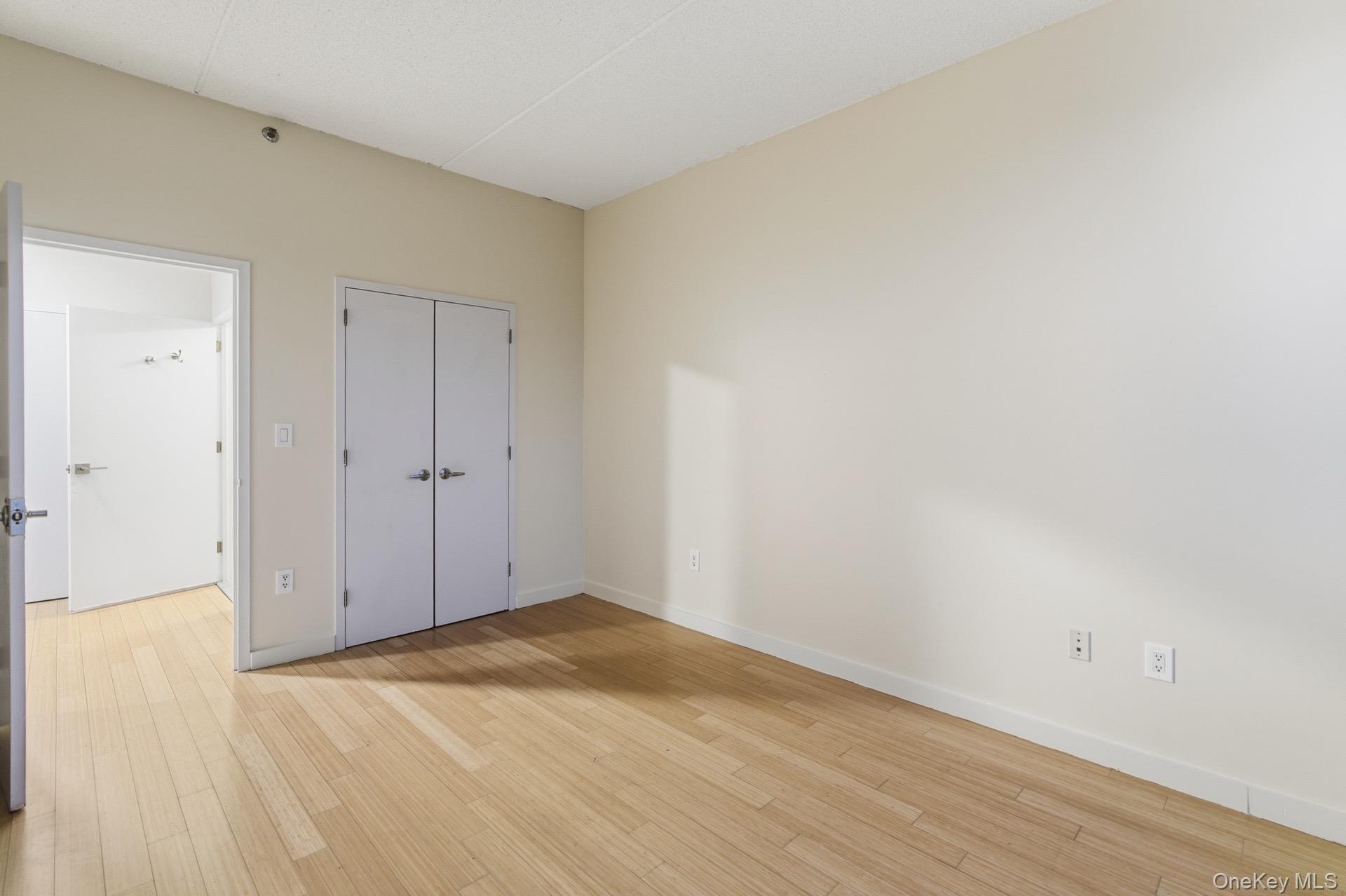 3044 3rd Avenue, Unit 9C Bronx, NY 10451 - Photo 8 of 15 Unfurnished bedroom featuring light wood-style floors and a closet