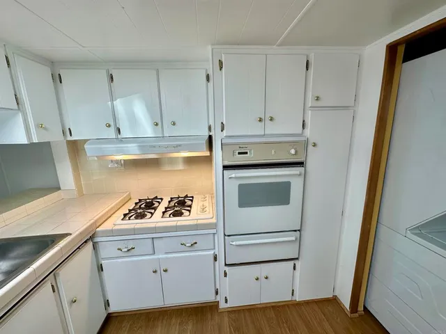 a view of a kitchen with wooden floor and a refrigerator