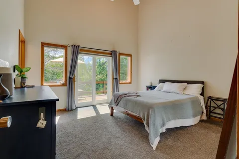 a spacious bedroom with a bed lamp and a large window