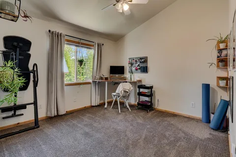 a view of a workspace with furniture and a window