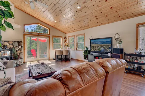 a living room with furniture a flat screen tv and a large window
