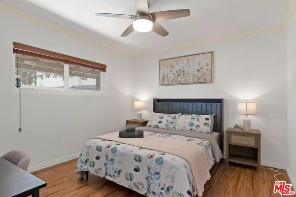 a bedroom with a bed and wooden floor