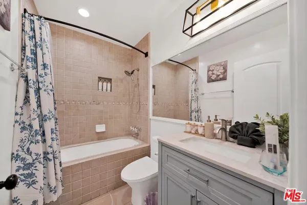 a bathroom with a sink a toilet a tub and shower