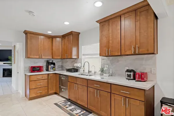 a kitchen with a sink dishwasher stove and cabinets