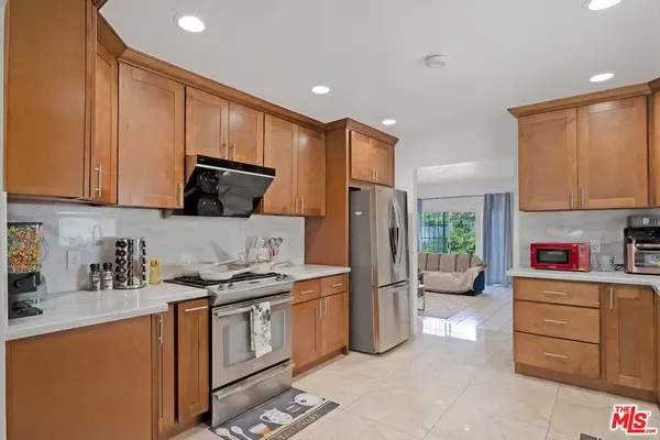 a kitchen with stainless steel appliances granite countertop a refrigerator stove and sink