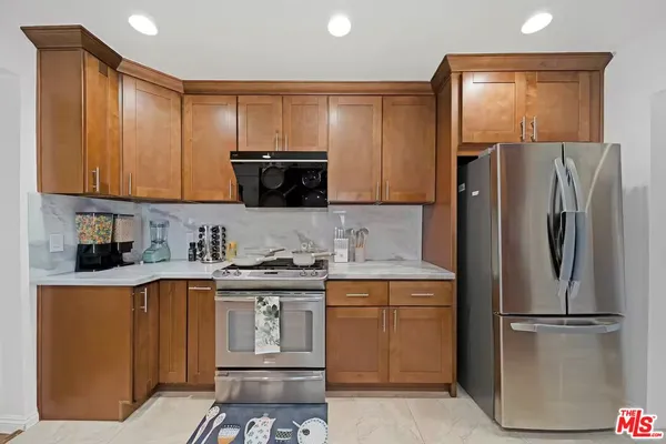a kitchen with a sink a refrigerator and cabinets