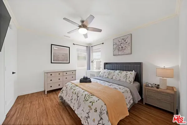 a bedroom with a bed and painting on the wall