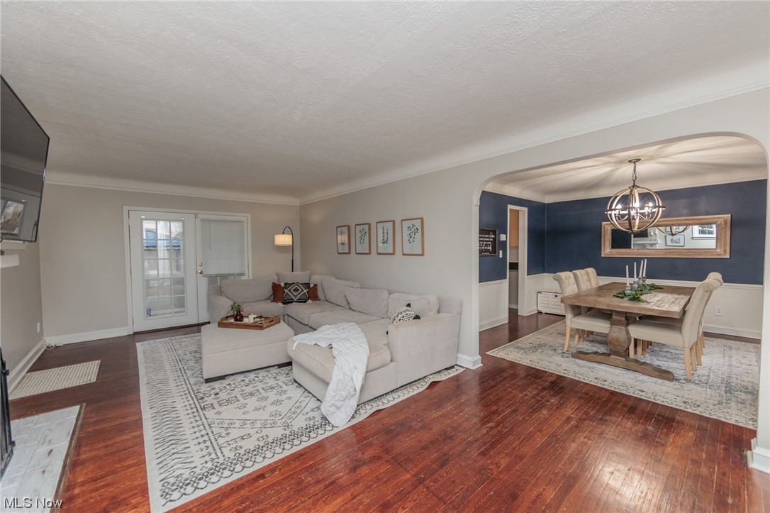 2199 Cranston Road Cleveland, OH 44118 - Photo 14 of 40 Living room featuring ornamental molding, an inviting chandelier, a textured ceiling, and dark hardwood / wood-style floors