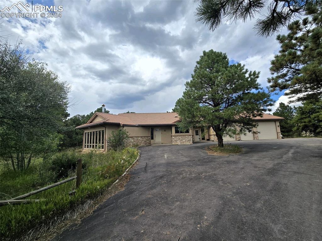 15850 Siesta Grove Colorado Springs, CO 80908 - Photo 1 of 4 a view of a house with a trees and pathway