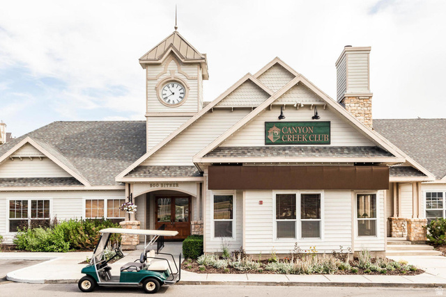 900 Bitner Road, Unit H35 Park City, UT 84098 - Photo 12 of 14 Charming Colonial-style clubhouse featuring a prominent clock tower, white horizontal siding, and a covered entry portico