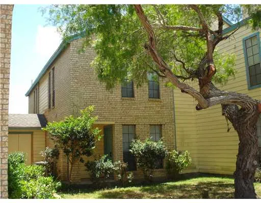 a view of a house with a yard and potted plants