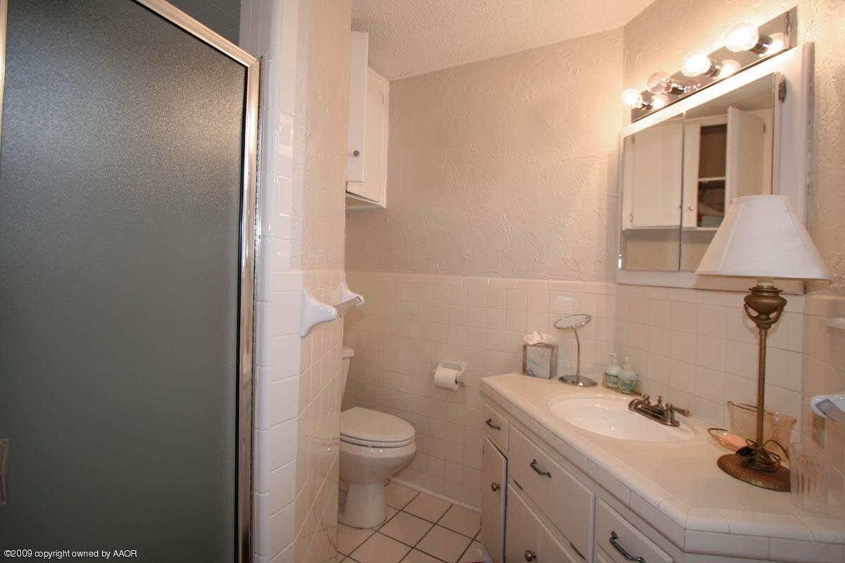 6015 Elmhurst Road Amarillo, TX 79106 - Photo 12 of 15 a bathroom with a sink a toilet and mirror