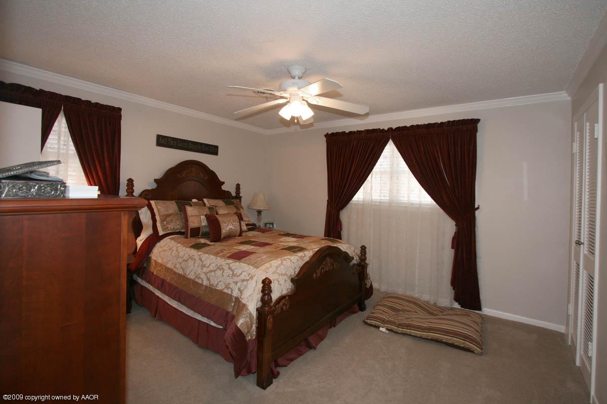 6015 Elmhurst Road Amarillo, TX 79106 - Photo 13 of 15 a bedroom with a bed and a chandelier