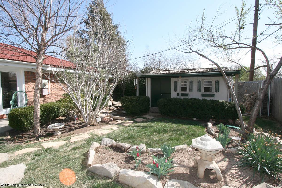 6015 Elmhurst Road Amarillo, TX 79106 - Photo 15 of 15 a backyard of a house with table and chairs under an umbrella