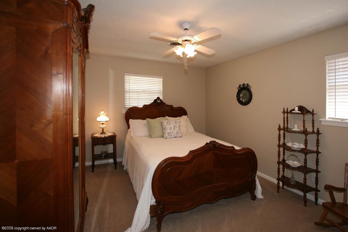 6015 Elmhurst Road Amarillo, TX 79106 - Photo 3 of 15 a bedroom with a bed and a chandelier