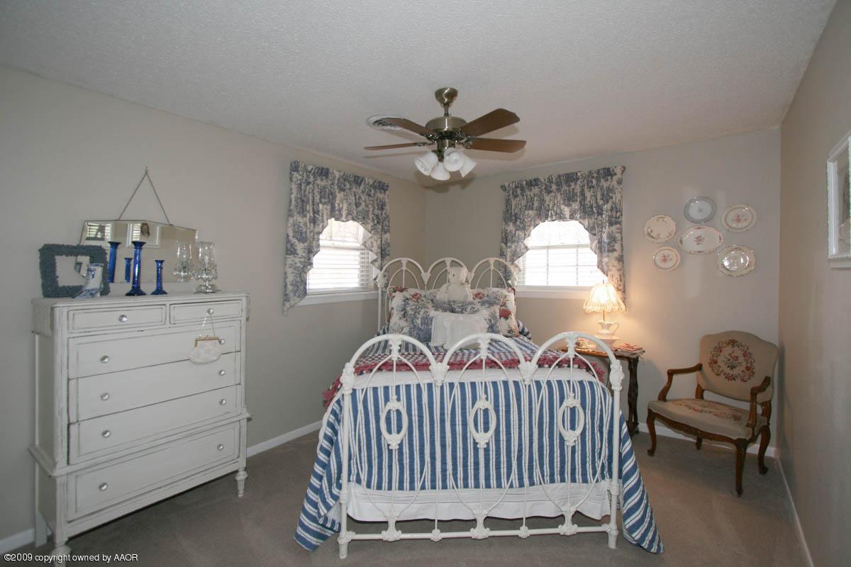 6015 Elmhurst Road Amarillo, TX 79106 - Photo 4 of 15 a bedroom with a bed and a chandelier