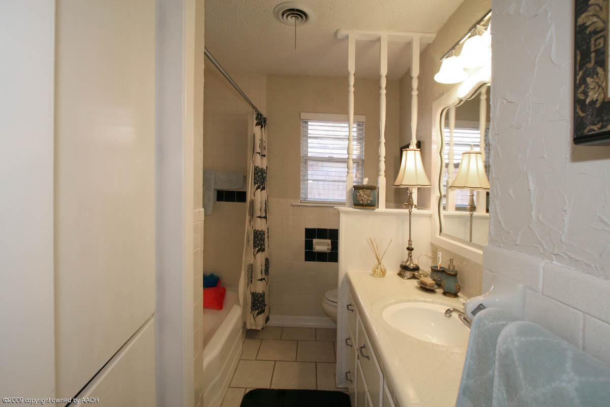 6015 Elmhurst Road Amarillo, TX 79106 - Photo 8 of 15 a bathroom with a tub sink mirror and a bathtub