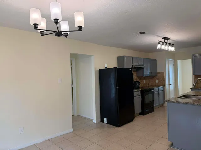 a kitchen with a refrigerator and a stove