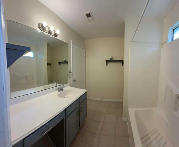 a bathroom with a sink a tub and a mirror