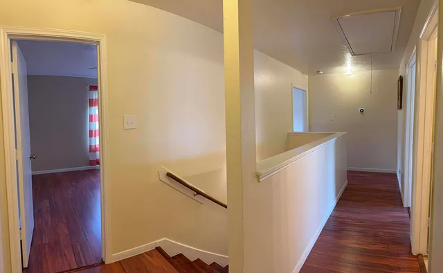 a view of a hallway with wooden floor