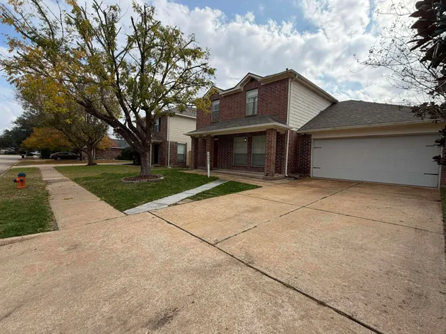 a view of a house with a yard and large tree